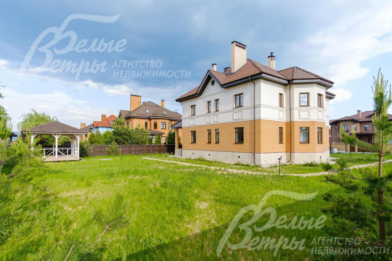 На участке газон, высажены хвойные деревья