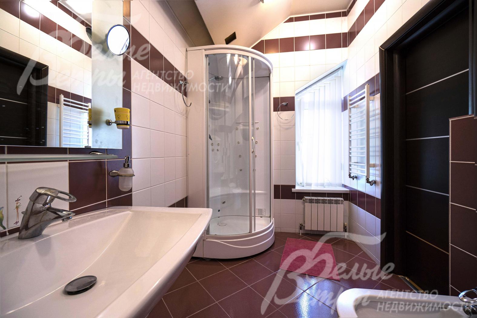 Санузел на втором этаже отделан контрастной плиткой в белых и коричневых цветах