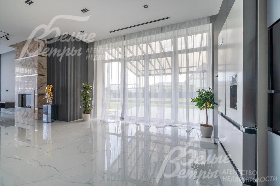 Выход на летнюю веранду из кухни через раздвижные стеклянные двери с шириной проема 1,75 м