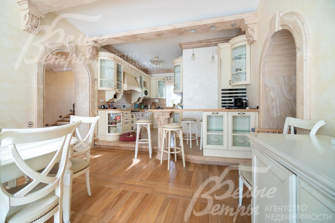 Кухня - на подиуме, зонирована барной стойкой 