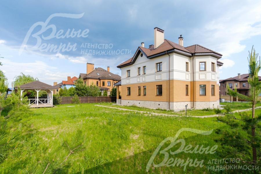 На участке газон, высажены хвойные деревья