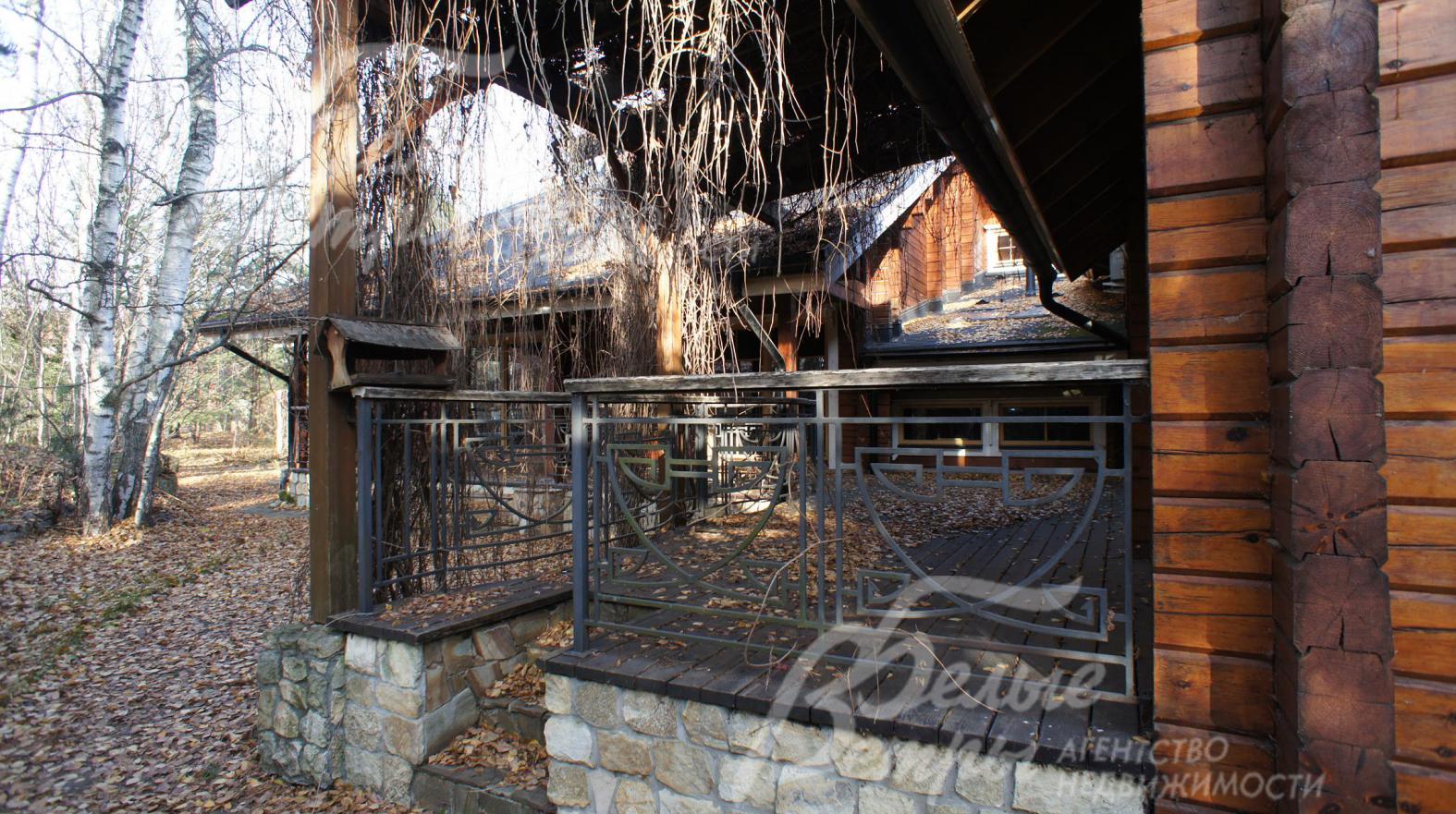 Широкая терраса из лиственницы с кованым оригинальным ограждением