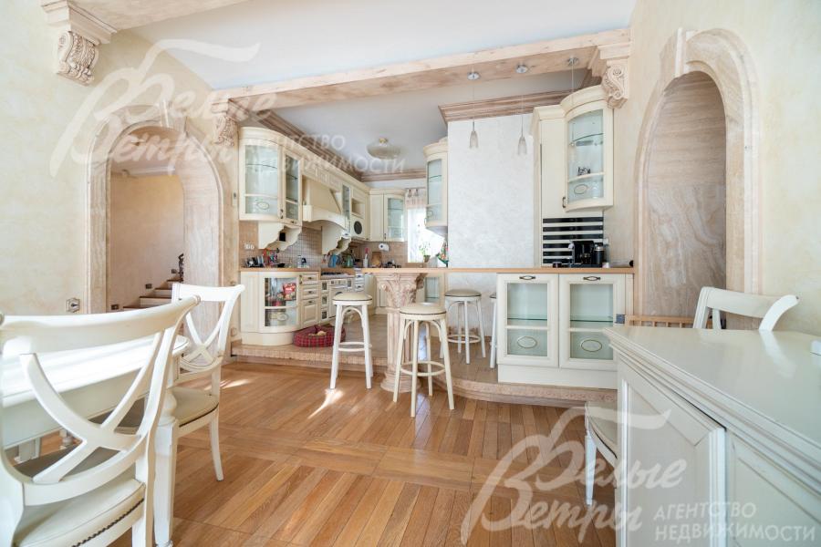 Кухня - на подиуме, зонирована барной стойкой 