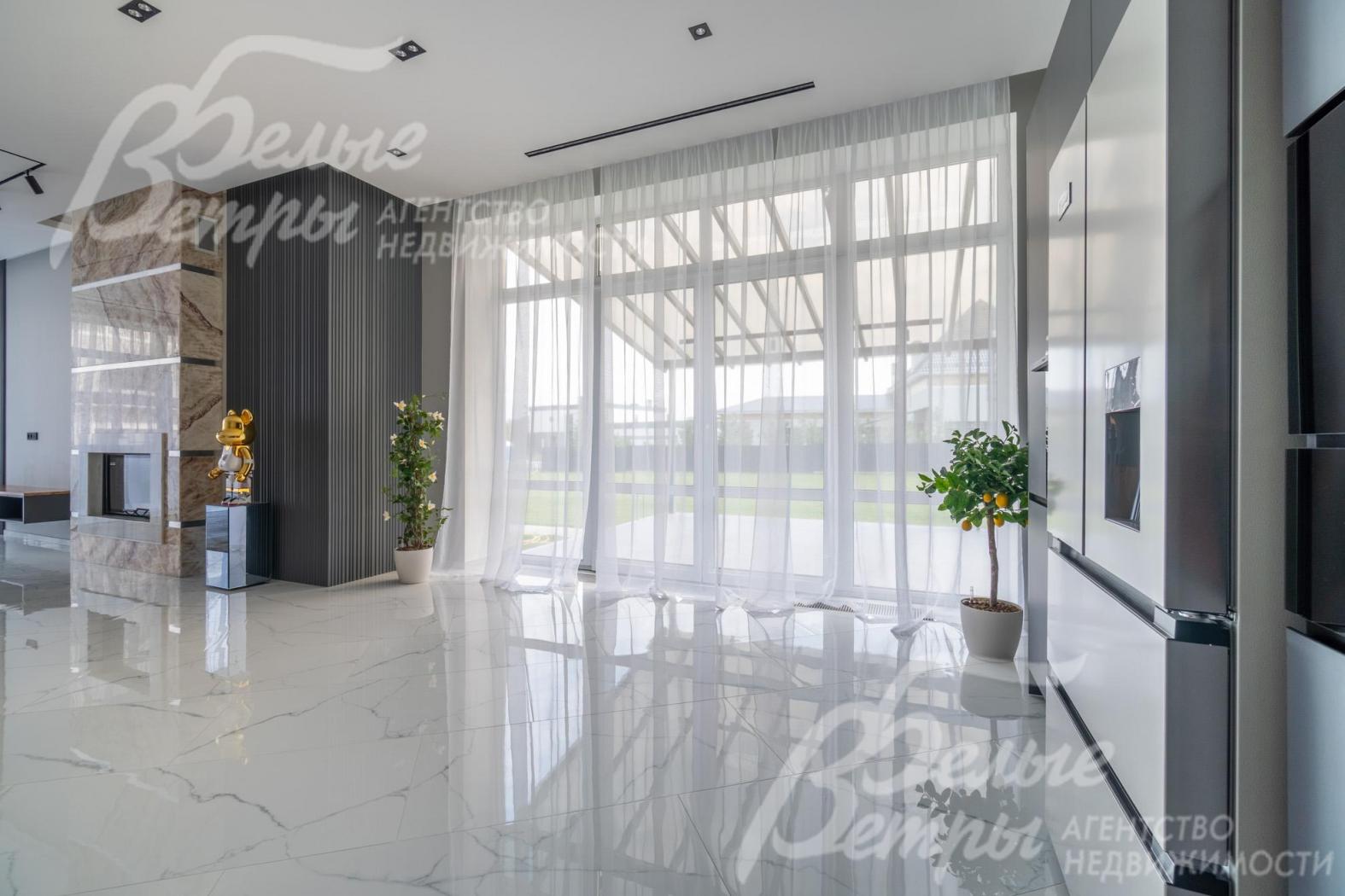 Выход на летнюю веранду из кухни через раздвижные стеклянные двери с шириной проема 1,75 м