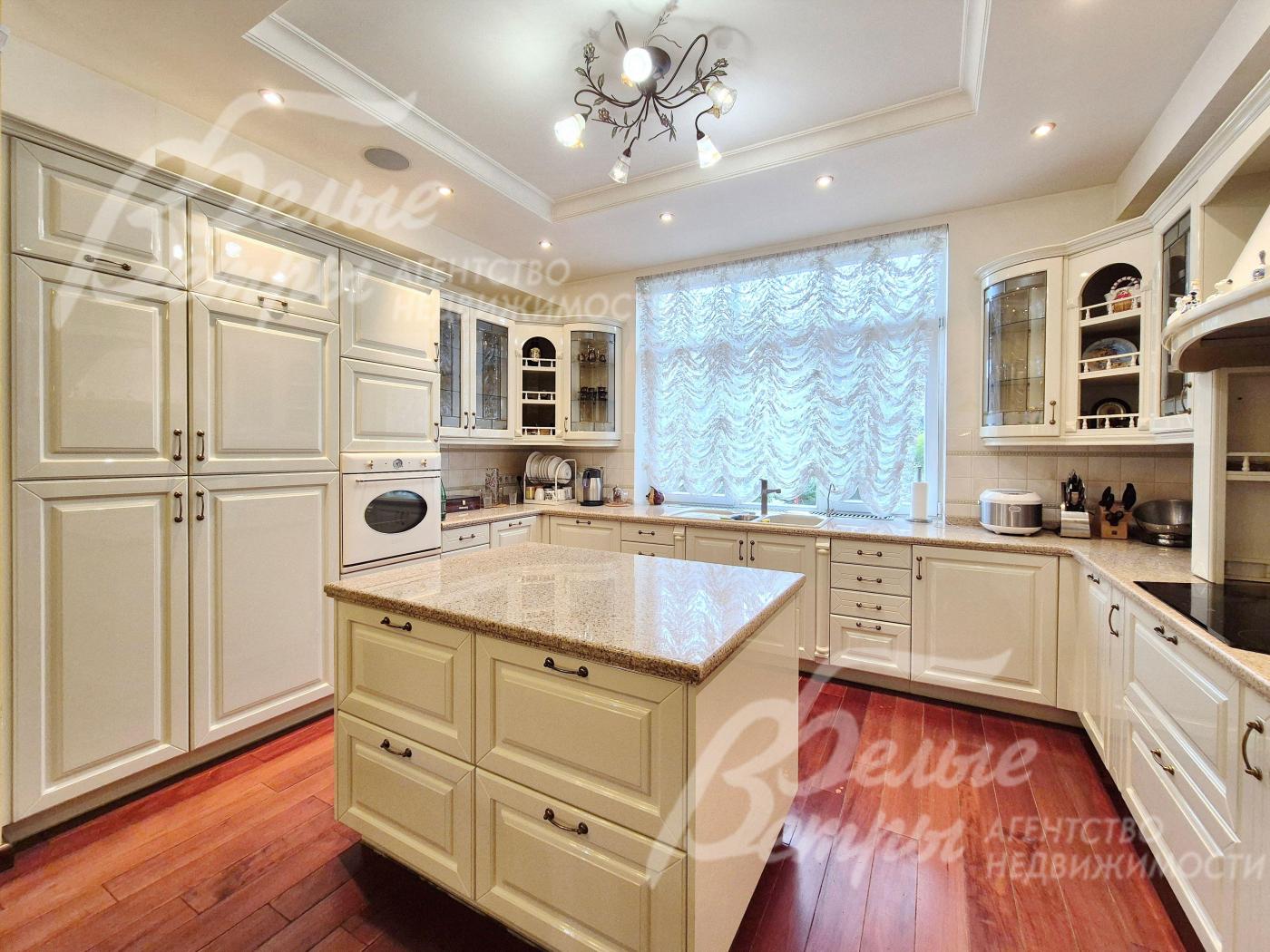 Кухня производства Италии, с глянцевыми филенчатыми фасадами из МДФ и столешницей из натурального камня.