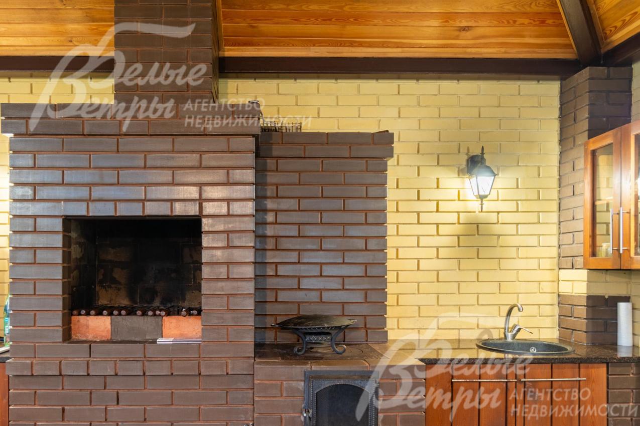 Печь из тёмного кирпича - с варочной зоной с чугунной решёткой, гармонично вписана в интерьер беседки