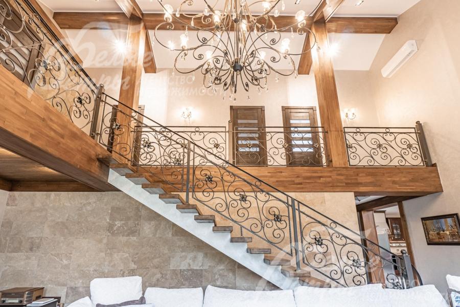 В гостиной -  красивая "парящая" лестница и изящная люстра 