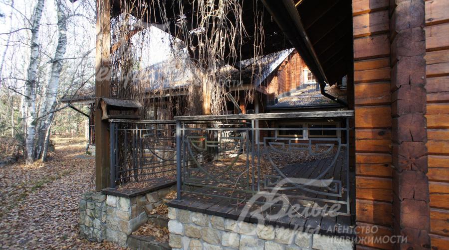 Широкая терраса из лиственницы с кованым оригинальным ограждением